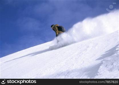 Snowboard freerider in the mountains with blue sky in the background