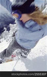 Snowboarder coming down snowy hill (selective focus)