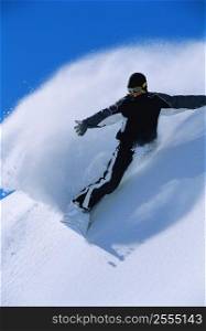 Snowboarder coming down snowy hill smiling