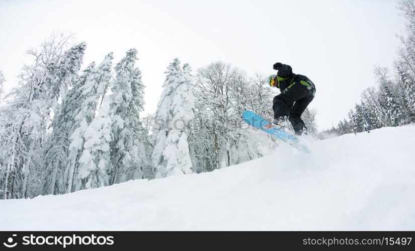 Snowboarder doing a jump and free ride on powder snow at winter season