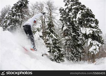 Snowboarder doing a jump and free ride on powder snow at winter season