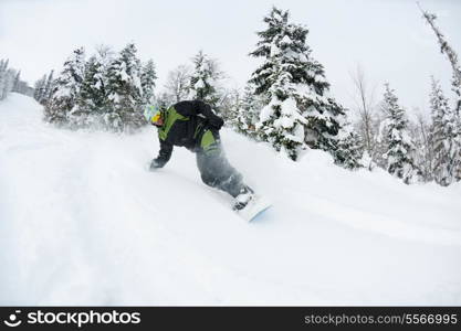 Snowboarder doing a jump and free ride on powder snow at winter season