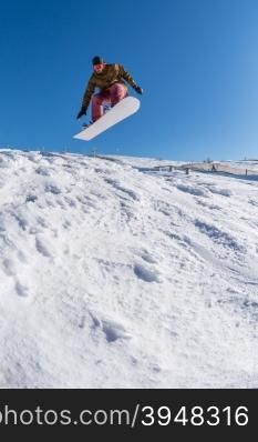 Snowboarder executing a radical jump against blue sky.