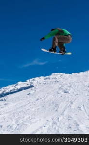 Snowboarder executing a radical jump against blue sky.