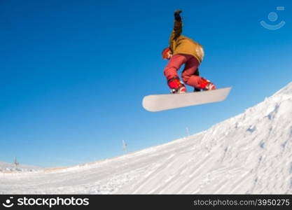 Snowboarder executing a radical jump against blue sky.