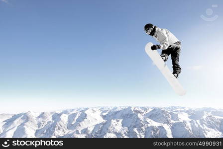 Snowboarder making high jump in clear blue sky. Snowboarding sport