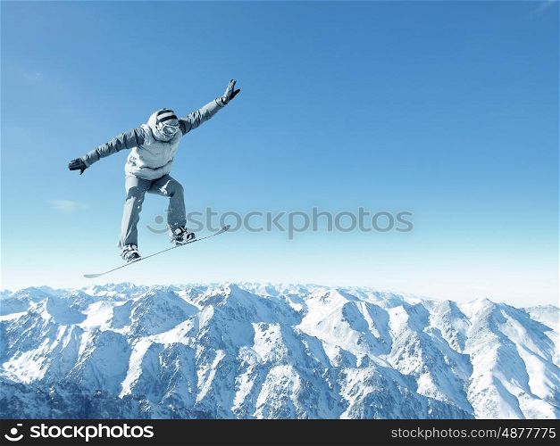 Snowboarder making jump high in clear sky. Snowboarding