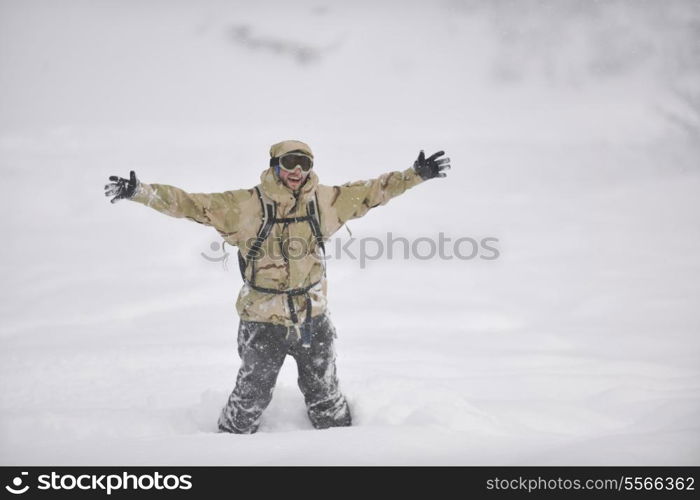 snowboarder relaxing and posing at sunny day on winter season with blue sky in background