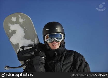 snowboarder relaxing and posing at sunny day on winter season with blue sky in background