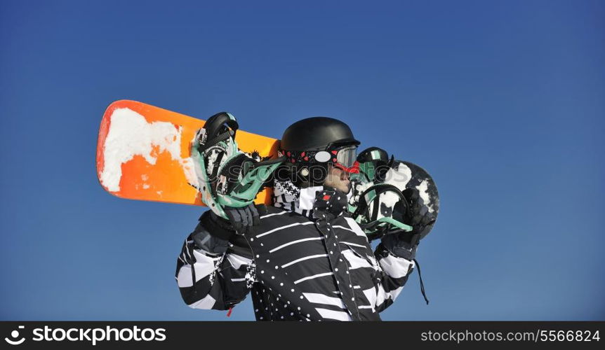 snowboarder relaxing and posing at sunny day on winter season with blue sky in background