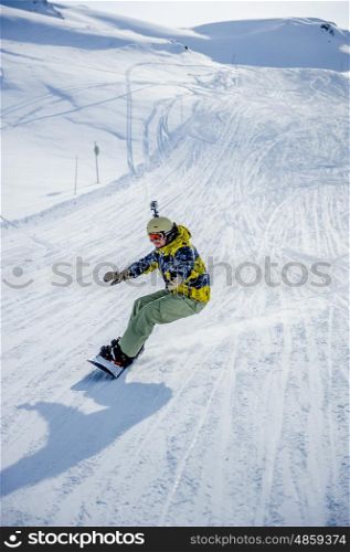 Snowboarder riding at French Alps mountain slopes. Val-d'Isere, France