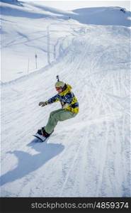 Snowboarder riding at French Alps mountain slopes. Val-d'Isere, France
