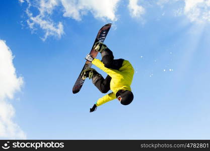 Snowboarding. Snowboarder making jump high in clear sky