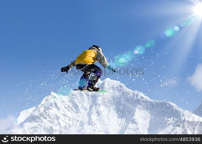 Snowboarding. Snowboarder making jump high in clear sky