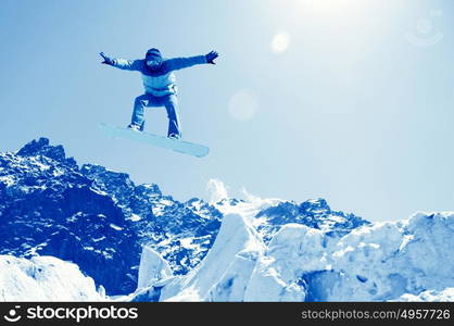 Snowboarding. Snowboarder making jump high in clear sky