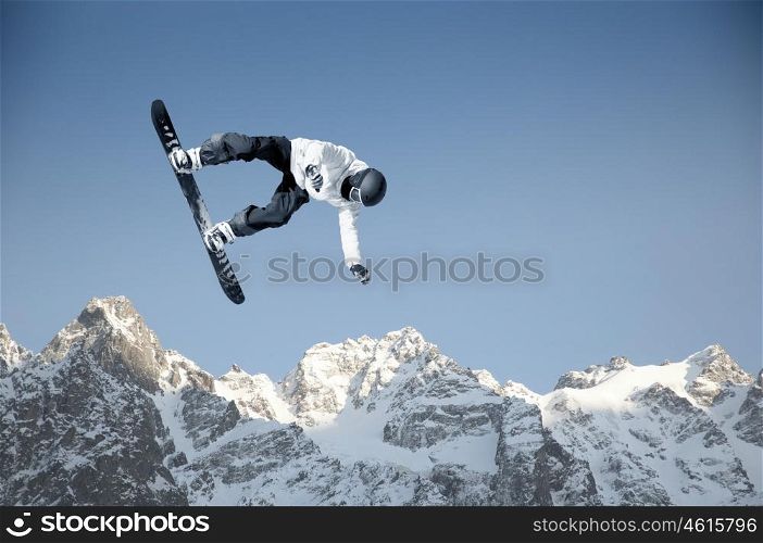 Snowboarding sport. Snowboarder making high jump in clear blue sky