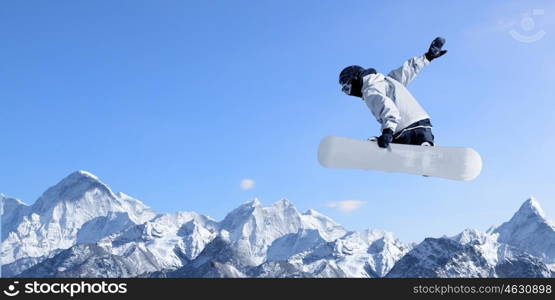 Snowboarding sport. Snowboarder making high jump in clear blue sky