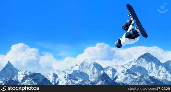 Snowboarding sport. Snowboarder making high jump in clear blue sky