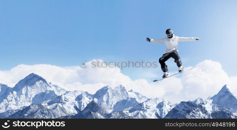 Snowboarding sport. Snowboarder making high jump in clear blue sky