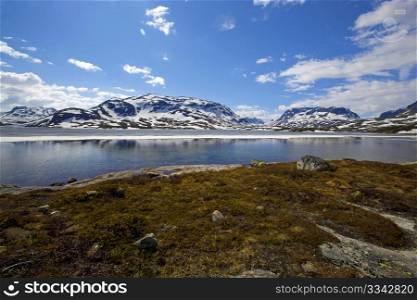 Snowcapped mountains reflecting in the water at Haukeli, Norway