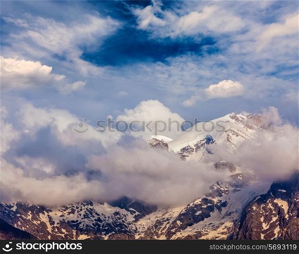 Snowcapped summit top of mountain in Himalayas in clouds. Himachal Pradesh, India