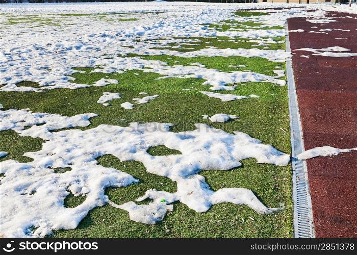 snowdrifts on outdoor soccer field in spring low season