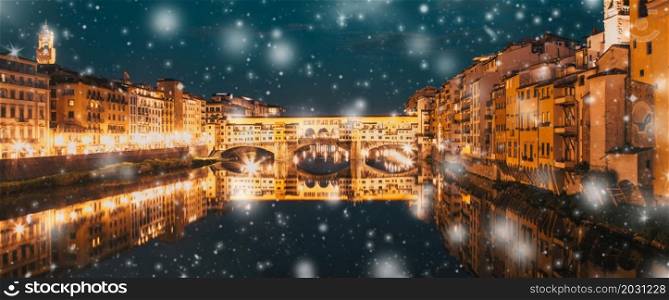 snowfall over Florence Ponte Vecchio on river Arno at night, winter in Italy