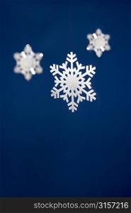 Snowflake Tree Decorations Against Blue Background