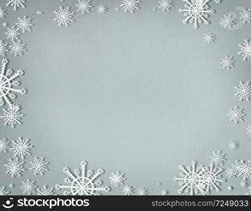 Snowflakes frame on cold gray background with copy space, top view. Christmas and winter holiday concept