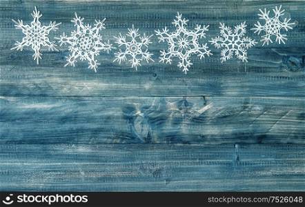 Snowflakes on rustic wooden background. Festive winter holidays decoration