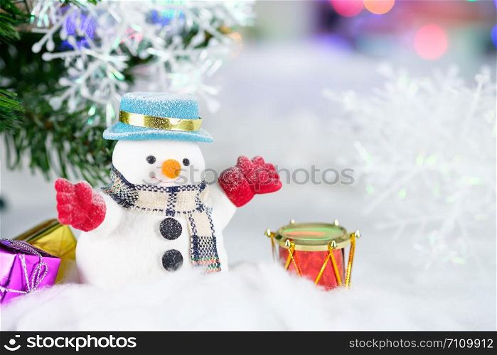 Snowman and Christmas decorations on bokeh background, with copy space for season greeting. Merry Christmas or Happy New Year.