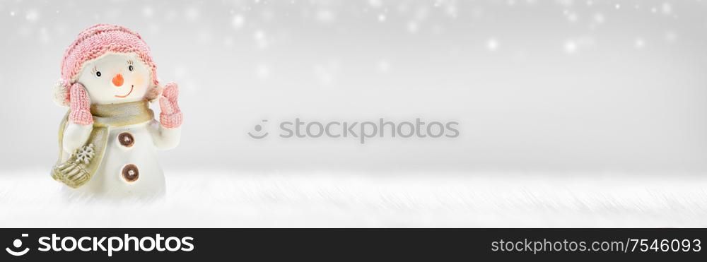 Snowman toy on frozen snow and bokeh lights winter background. Snowman toy on winter background
