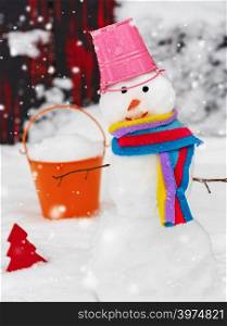 snowman with a bucket on his head on white snow, a winter day