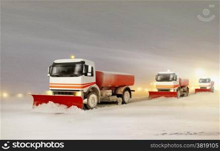Snowplow Trucks Removing the Snow from the Highway during a Cold Snowstorm Winter Day