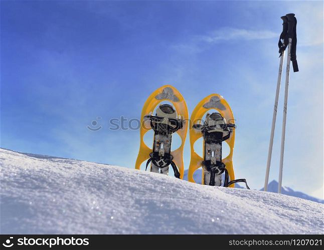 snowshoes planting in the snow in mountain under blue sky