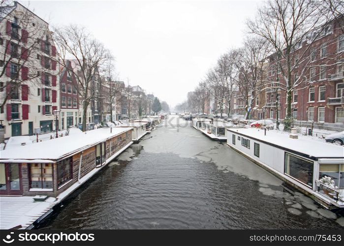 Snowy Amsterdam in the Netherlands in winter at sunset