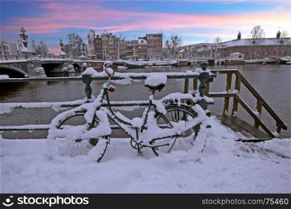 Snowy bicycle in Amsterdam city center the Netherlands at sunset