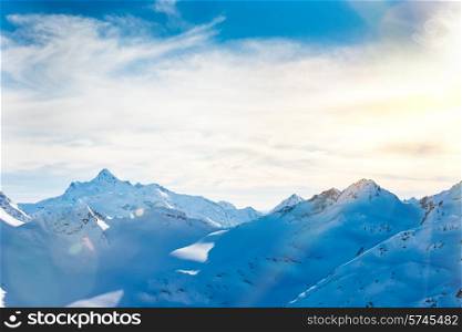 Snowy blue mountains in clouds. Winter ski resort