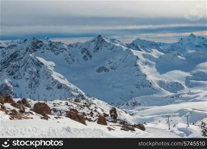 Snowy blue mountains in clouds. Winter ski resort