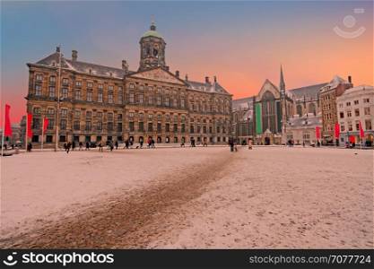 Snowy Damsquare in Amsterdam the Netherlands in winter at sunset