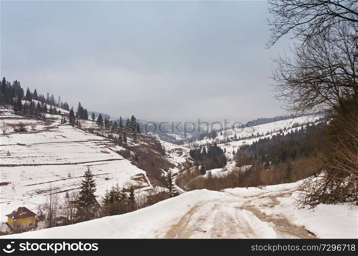 Snowy ground in winter Carpathian mountains. Extreme path rural dirt road on the hills
