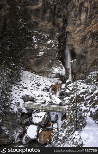 Snowy landscape with bridge and a waterfall on the background