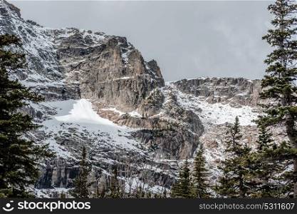 Snowy landscape with rocks and mountains at autumn with cloudy sky. Rocky Mountain National Park in Colorado, USA.