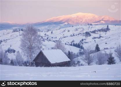 Snowy mountain hills with wooden cabin