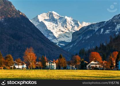 snowy mountain peak with village in autumn and spring, Europe travel destination