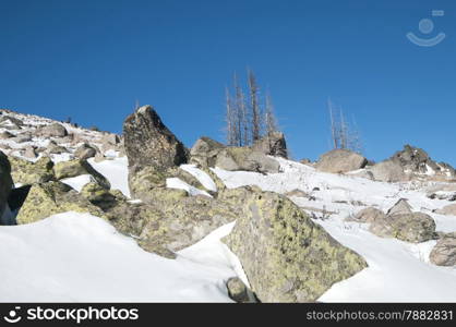 Snowy mountain rock ridge in clear sunny winter day