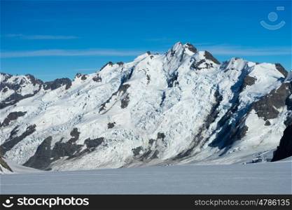 Snowy mountains. Natural mountain landscape with snow and clear blue sky
