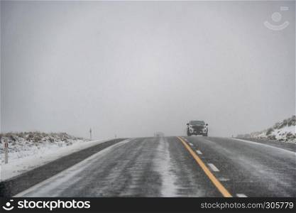 Snowy road in winter with car coming.
