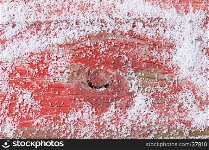 Snowy rustic red wooden background for Christmas holiday concept. Overhead view with copy space.