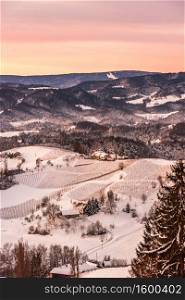 Snowy vineyard in winter at sunraise in Styria Austria Slovenia border. View at slovenian snowy hills from Austrian wine street.. Snowy vineyard in winter at sunraise in Styria Austria Slovenia border.